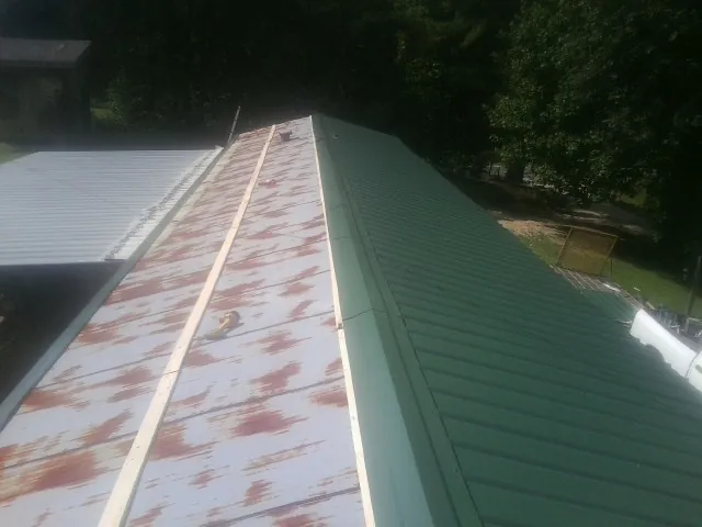 Old rusted panels beside newly installed green metal roofing — Wind Damage Roof Repair by Roofing Brothers in Ukiah